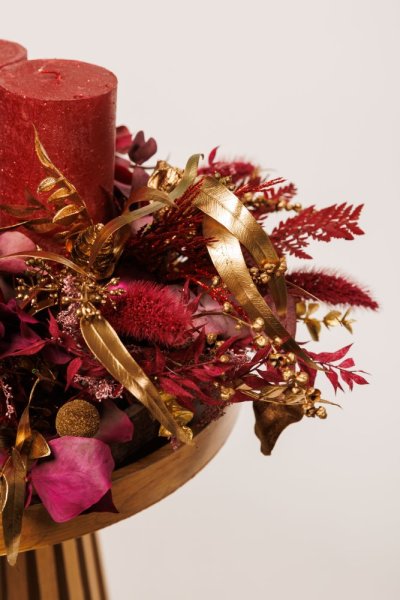 adventný veniec obsahuje jemné dekorácie, červené sviečky a sušené kvety