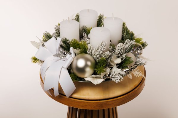 krásny elegantný adventný veniec so striebornými dekoráciami a bielymi sviecami 