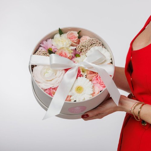 Kvetinový box ladený v jemných pastelových farbách, obsahuje mix sezónnych kvetov ako sú germiny, karafiáty a ruže.
