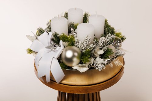 krásny elegantný adventný veniec so striebornými dekoráciami a bielymi sviecami 