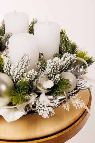 krásny elegantný adventný veniec so striebornými dekoráciami a bielymi sviecami 