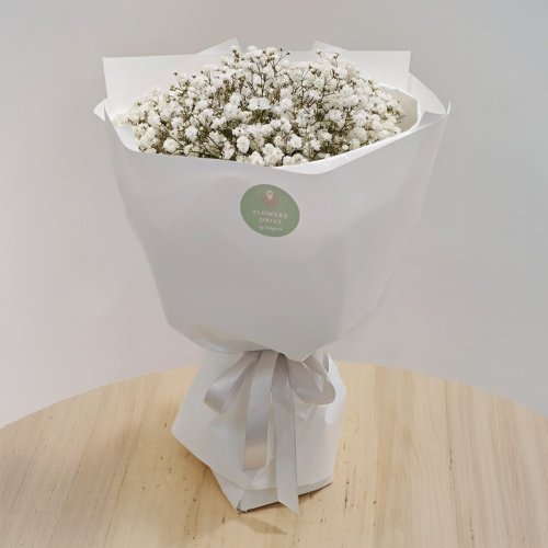 Bohatá nadýchaná kytica z gypsomilky v bielom dekoračnom papieri.