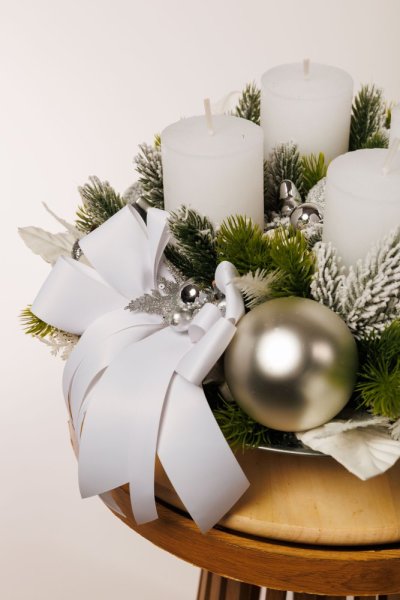 krásny elegantný adventný veniec so striebornými dekoráciami a bielymi sviecami 