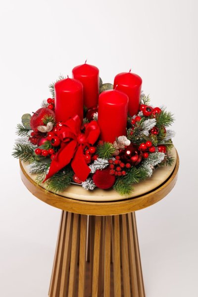 krásny červený adventný veniec s čečinou, červenou mašľou a červenými sviečkami
